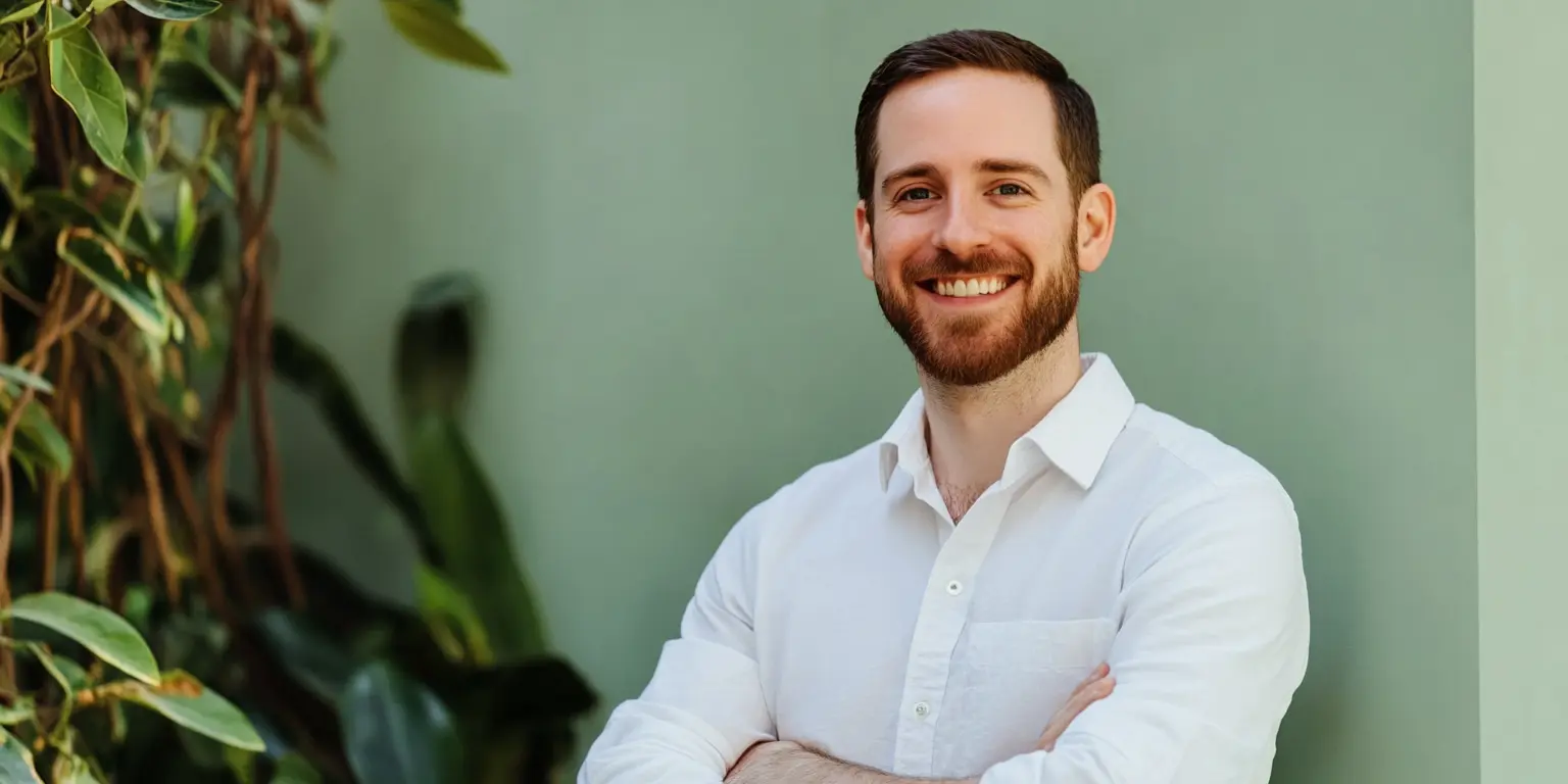 A man smiling with his arms crossed